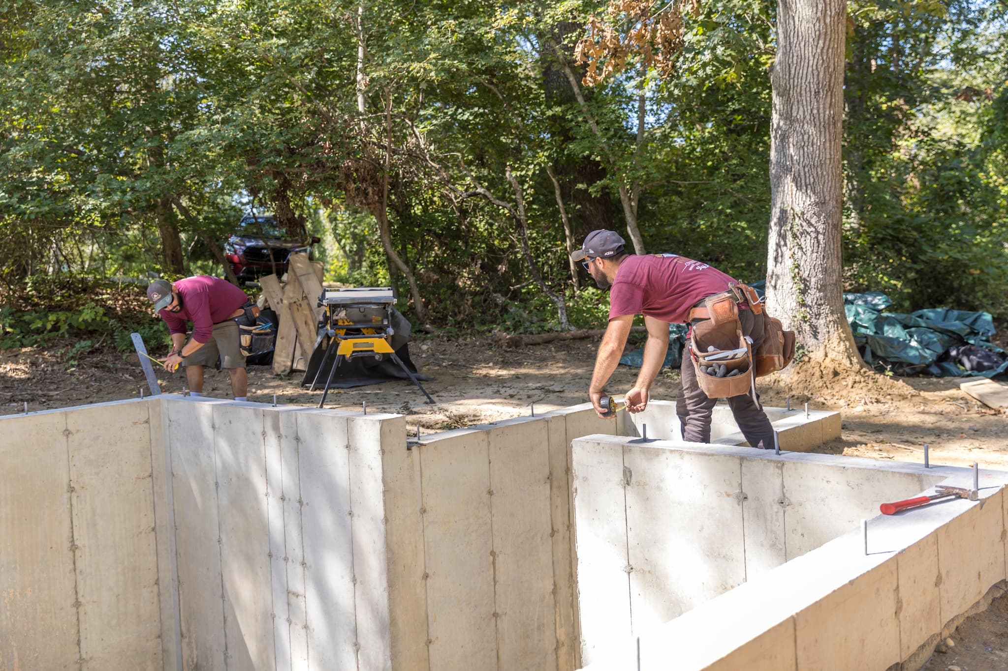 Two Tekton workers measuring the foundation for a home addition